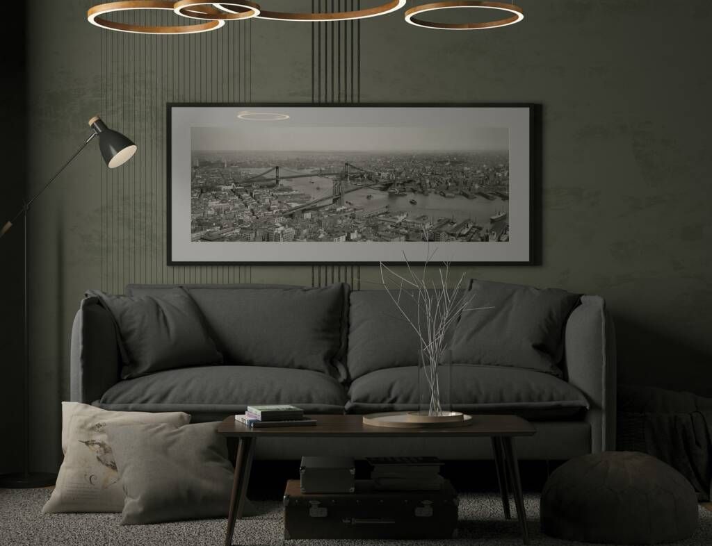 A living room with a couch , coffee table , lamp and picture on the wall.