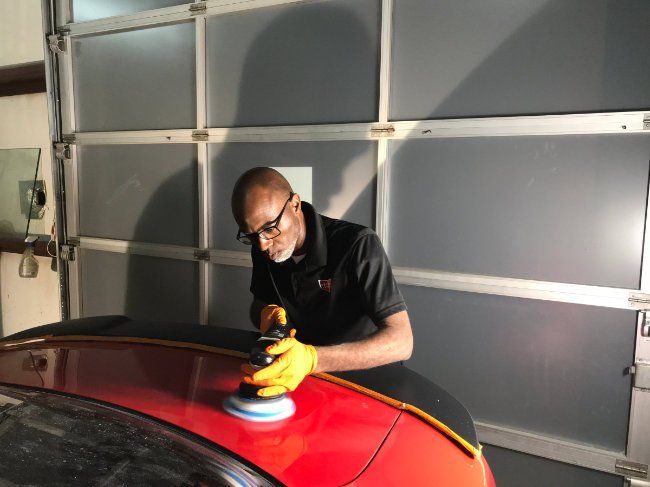polishing a red charger trunk
