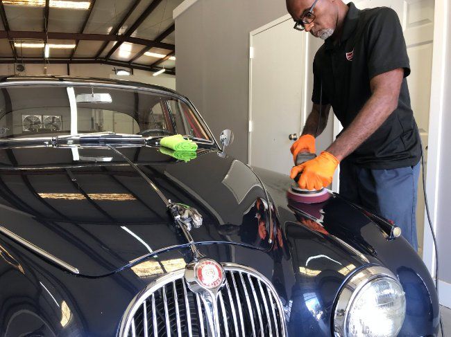polishing a glossy blue vintage jaguar