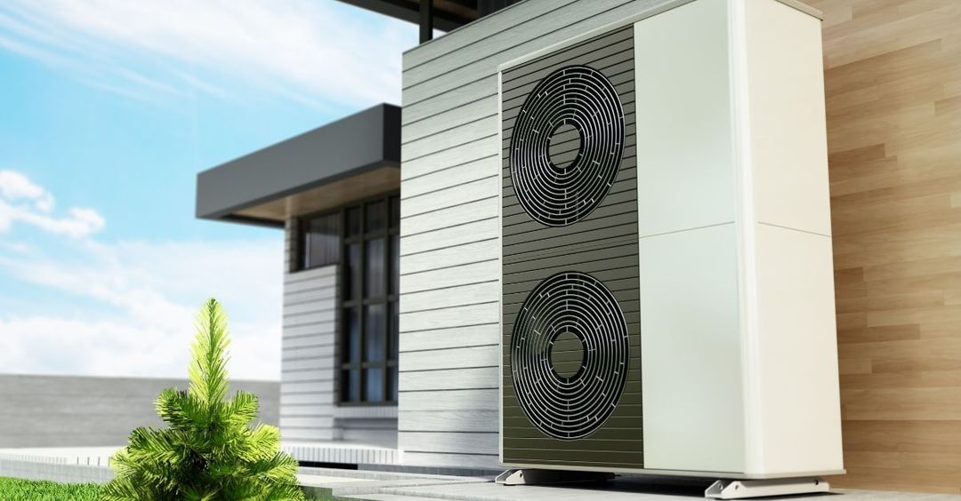 Una persona seduta su un divano usa il telefono per regolare un condizionatore d'aria a parete in soggiorno.