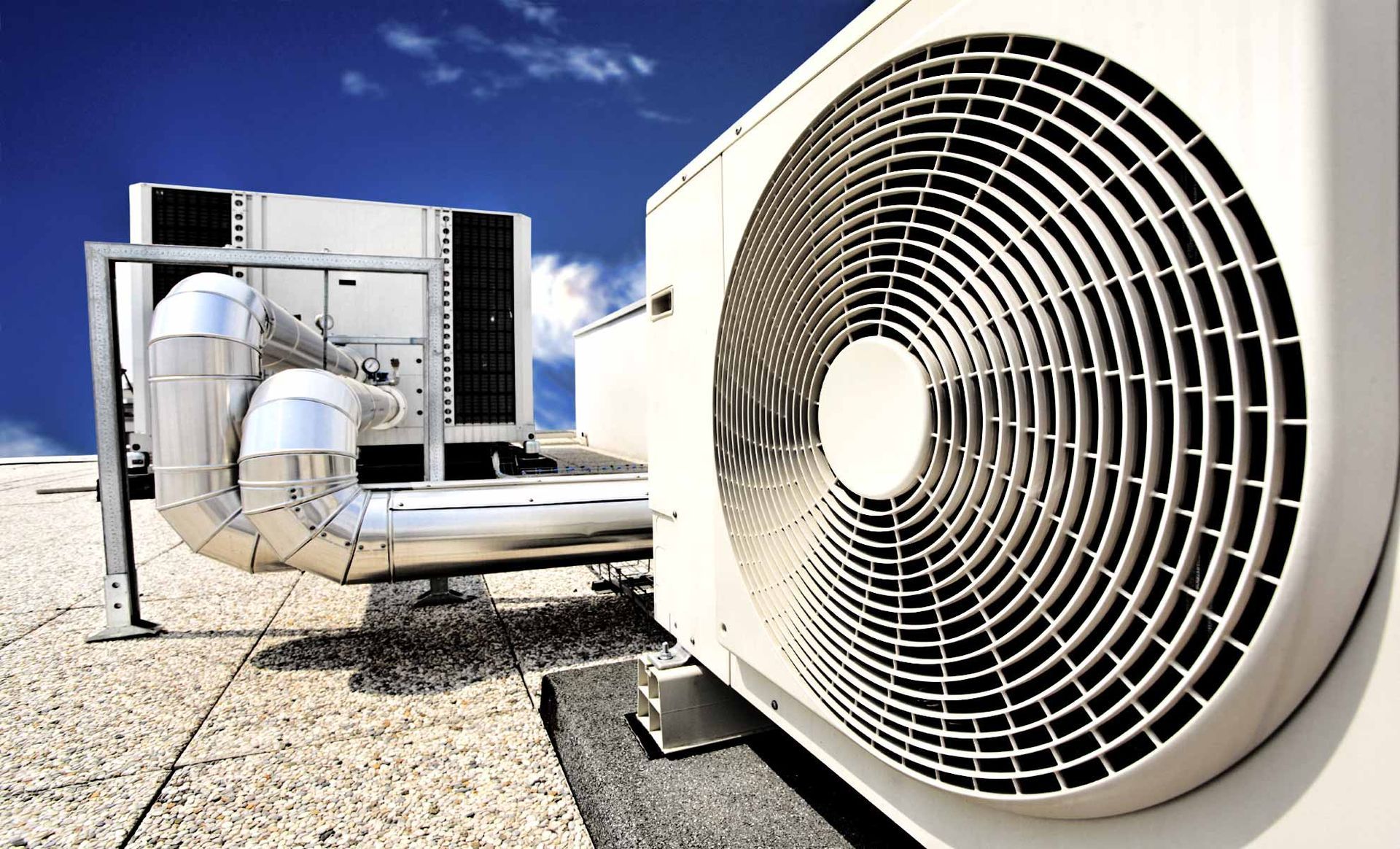 Una persona seduta su un divano in soggiorno usa uno smartphone per indicare un condizionatore d'aria a parete.