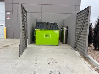 A green dumpster with the word jane on it