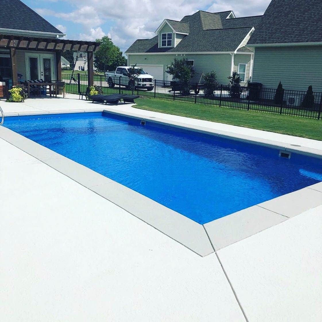 A large blue swimming pool in front of a house