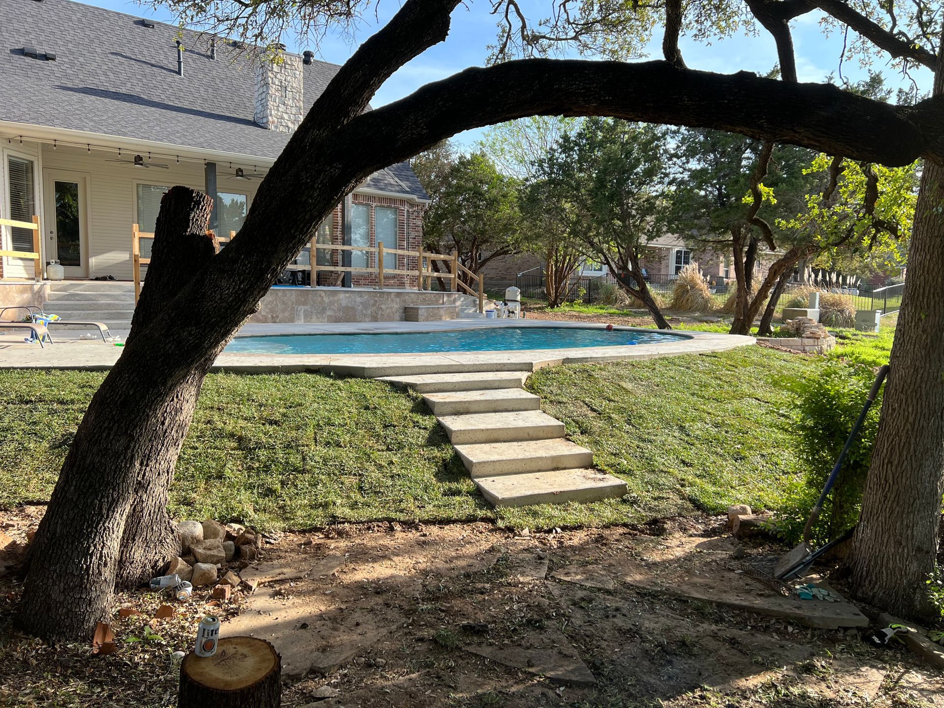 There is a swimming pool in the backyard of a house.