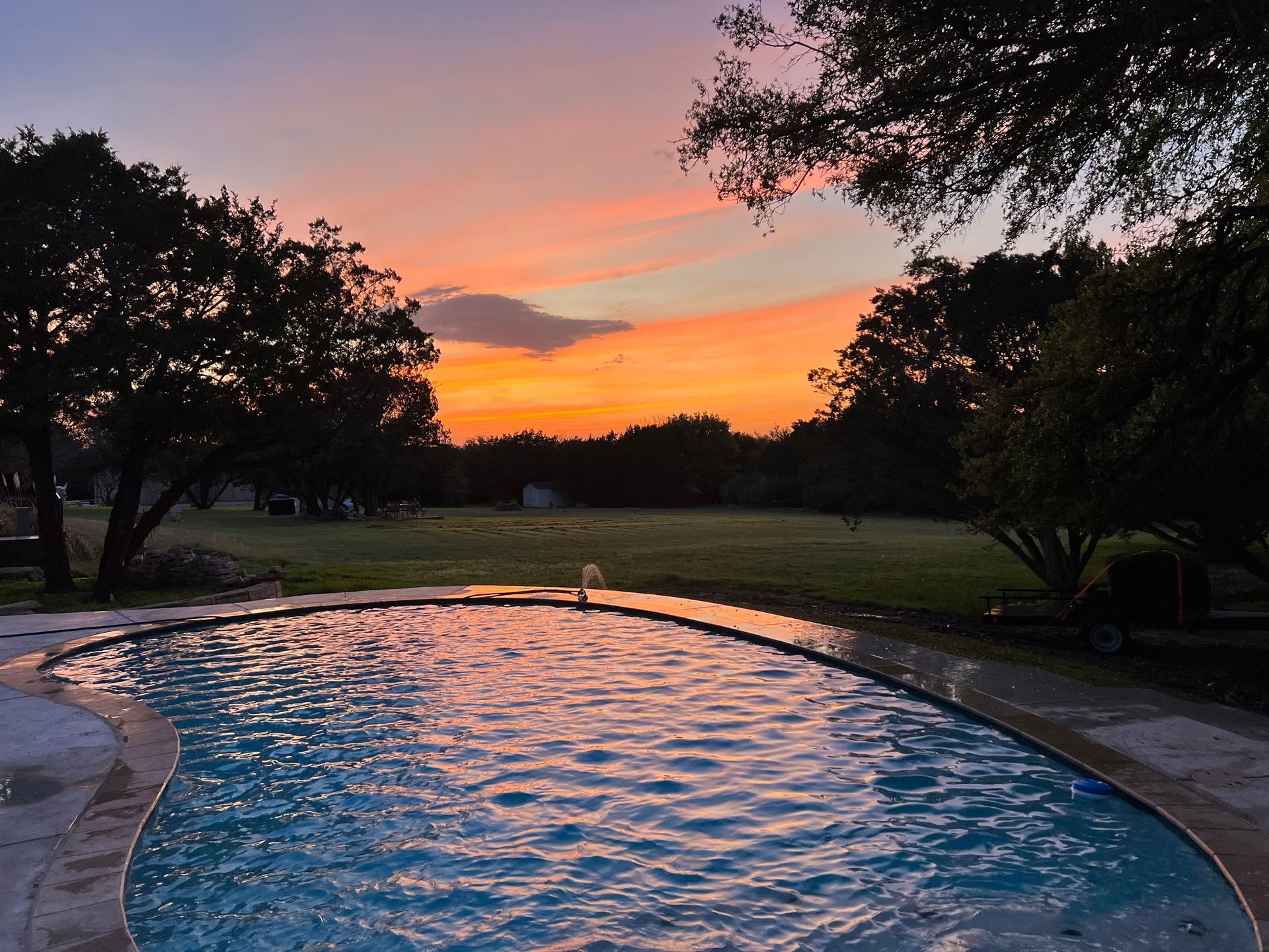 A swimming pool with a wooden deck surrounding it