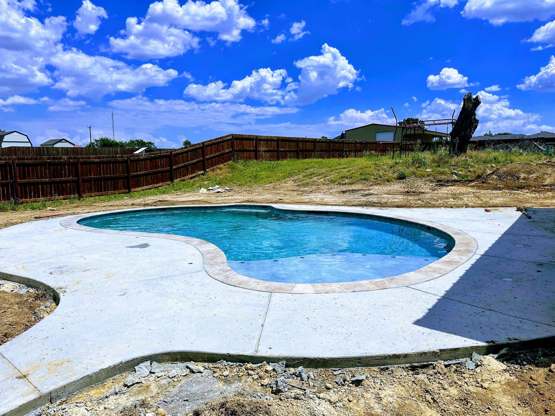 A group of construction workers are working on a swimming pool.