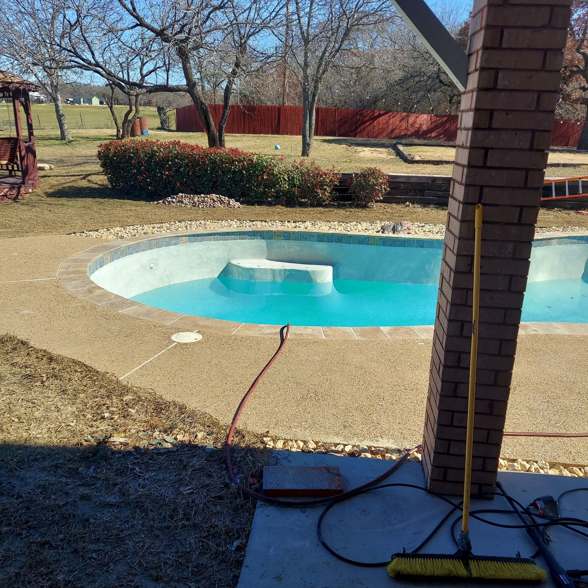 A large swimming pool in a backyard on a sunny day
