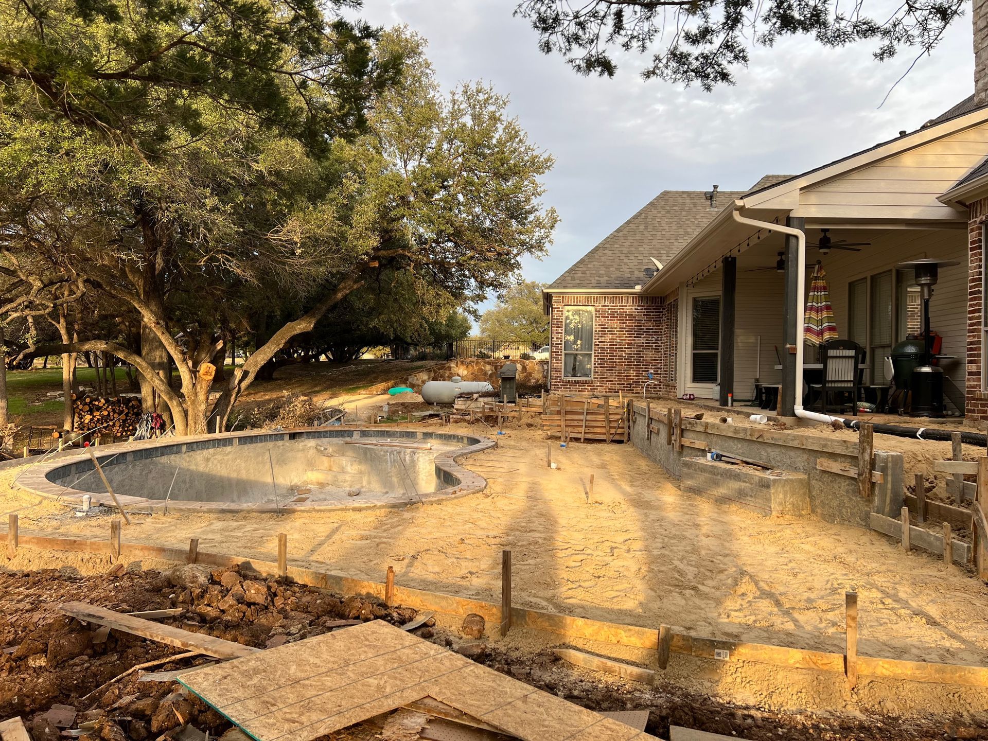 A swimming pool is being built in the backyard of a house.