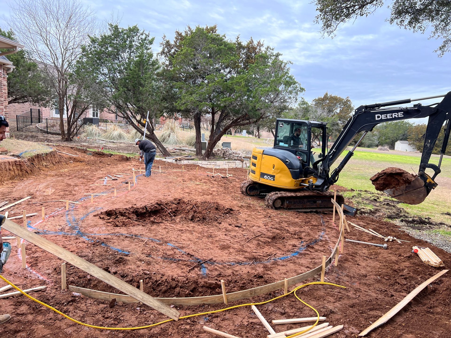 A yellow and black excavator is digging a hole in the dirt.