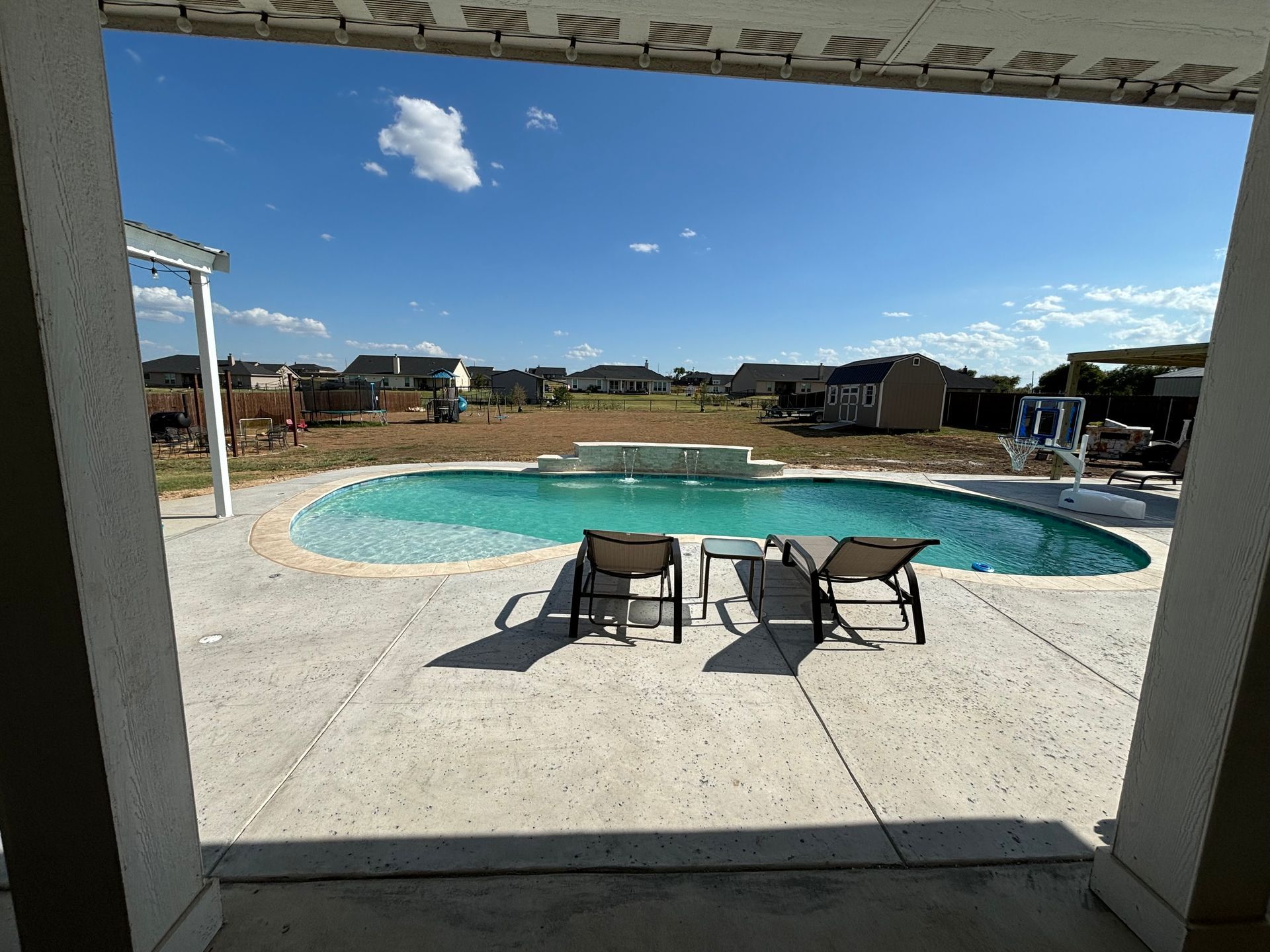 A view of a large swimming pool from a porch