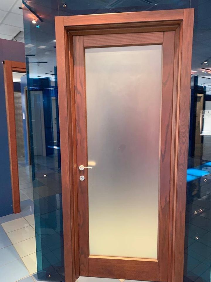 porta in legno scuro con elemento in vetro satinato