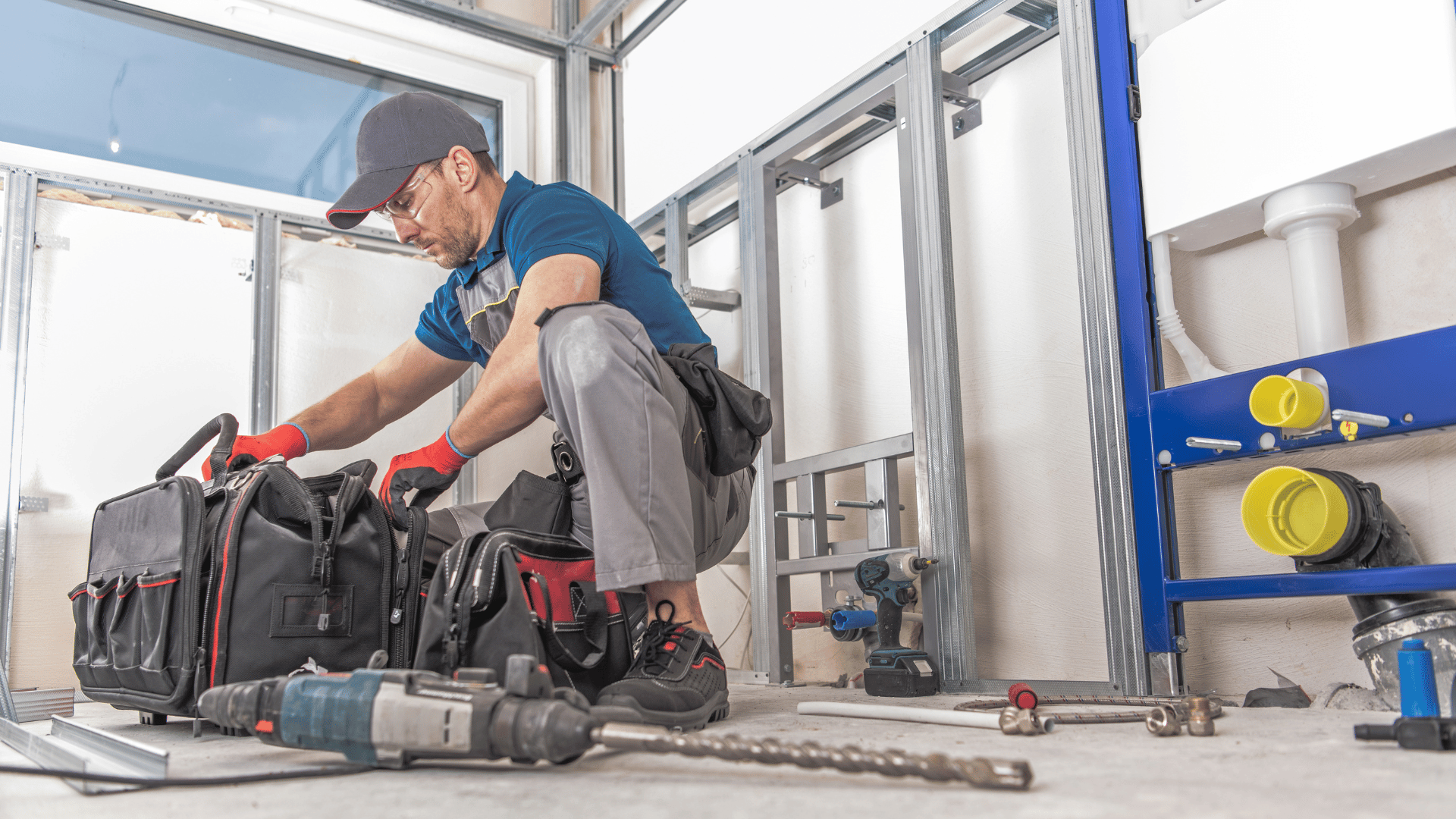 A plumber is working on a pipe in a bathroom.