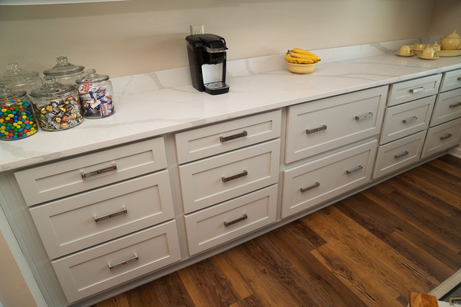 A kitchen counter with lots of drawers and a coffee maker.