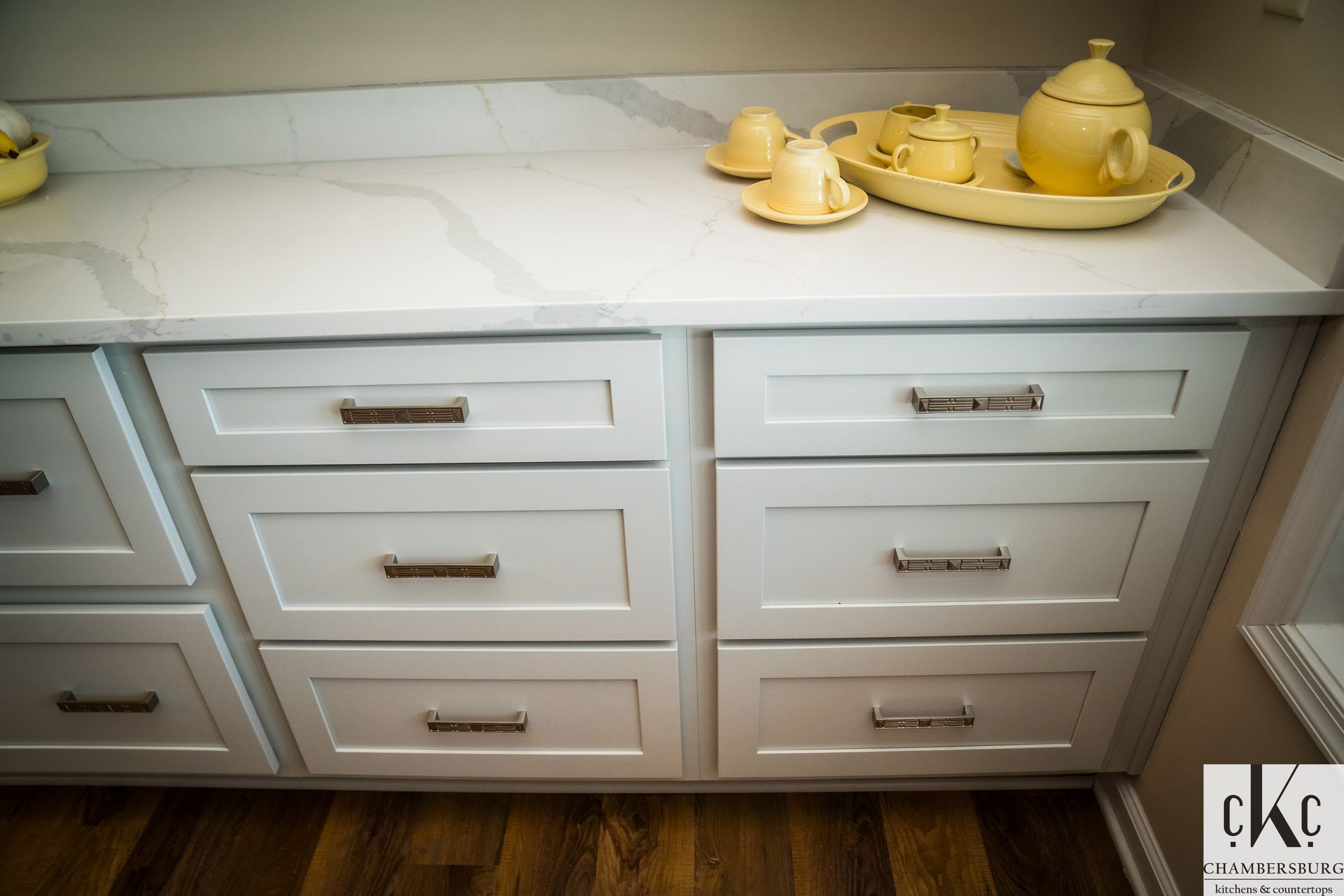 A kitchen counter with white drawers and a white counter top