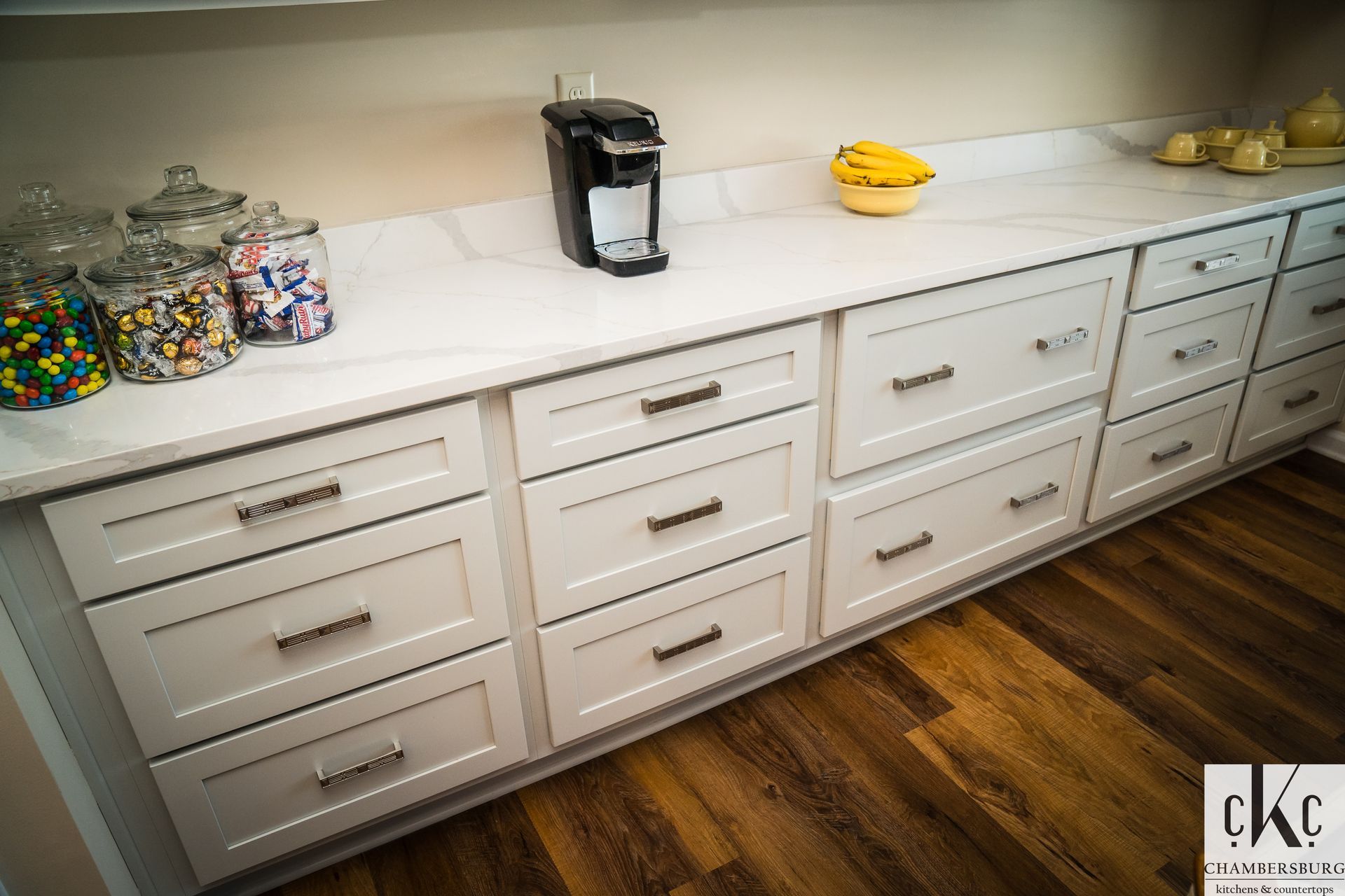 A kitchen counter with lots of drawers and a coffee maker.