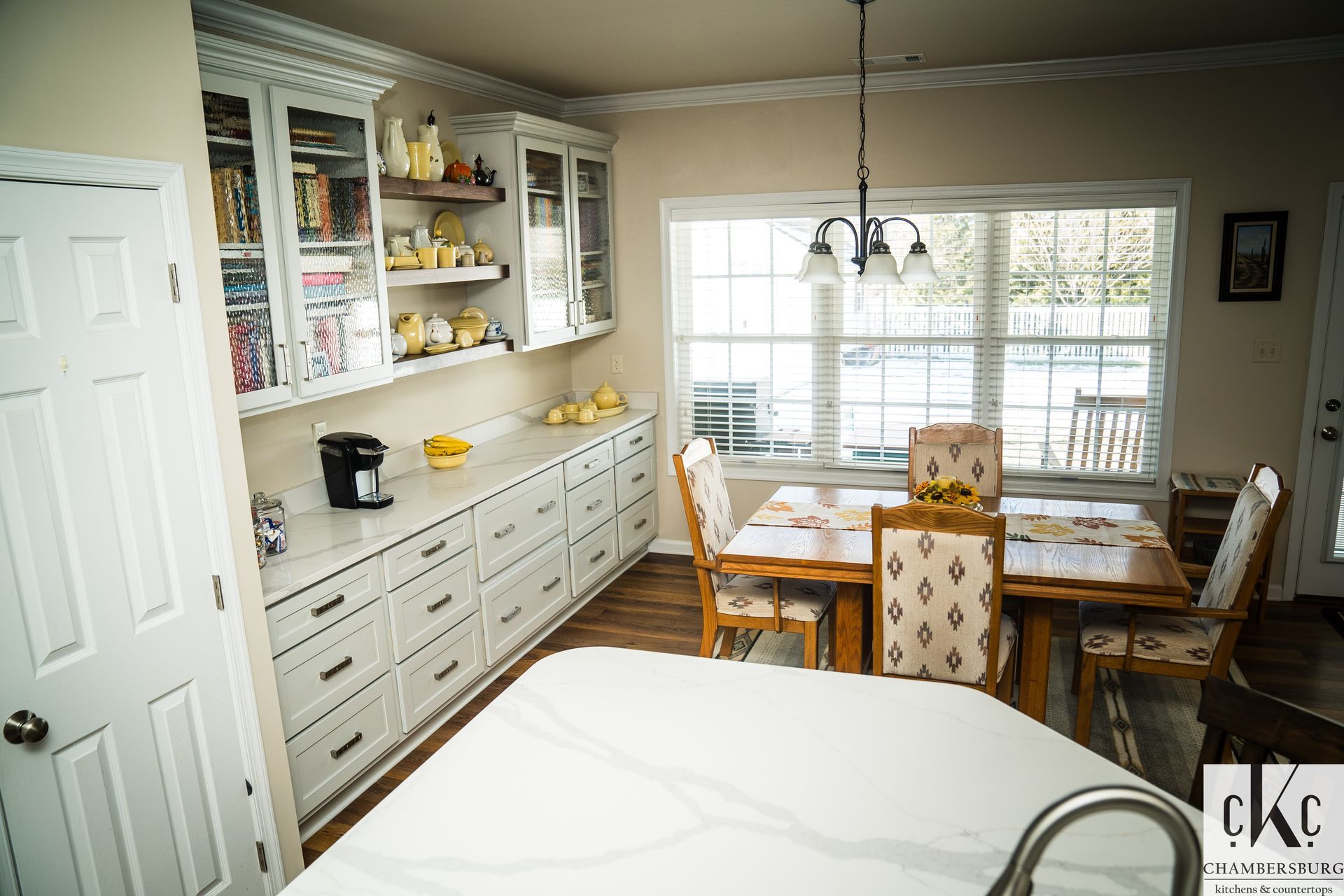 A kitchen with a table and chairs and a sink.