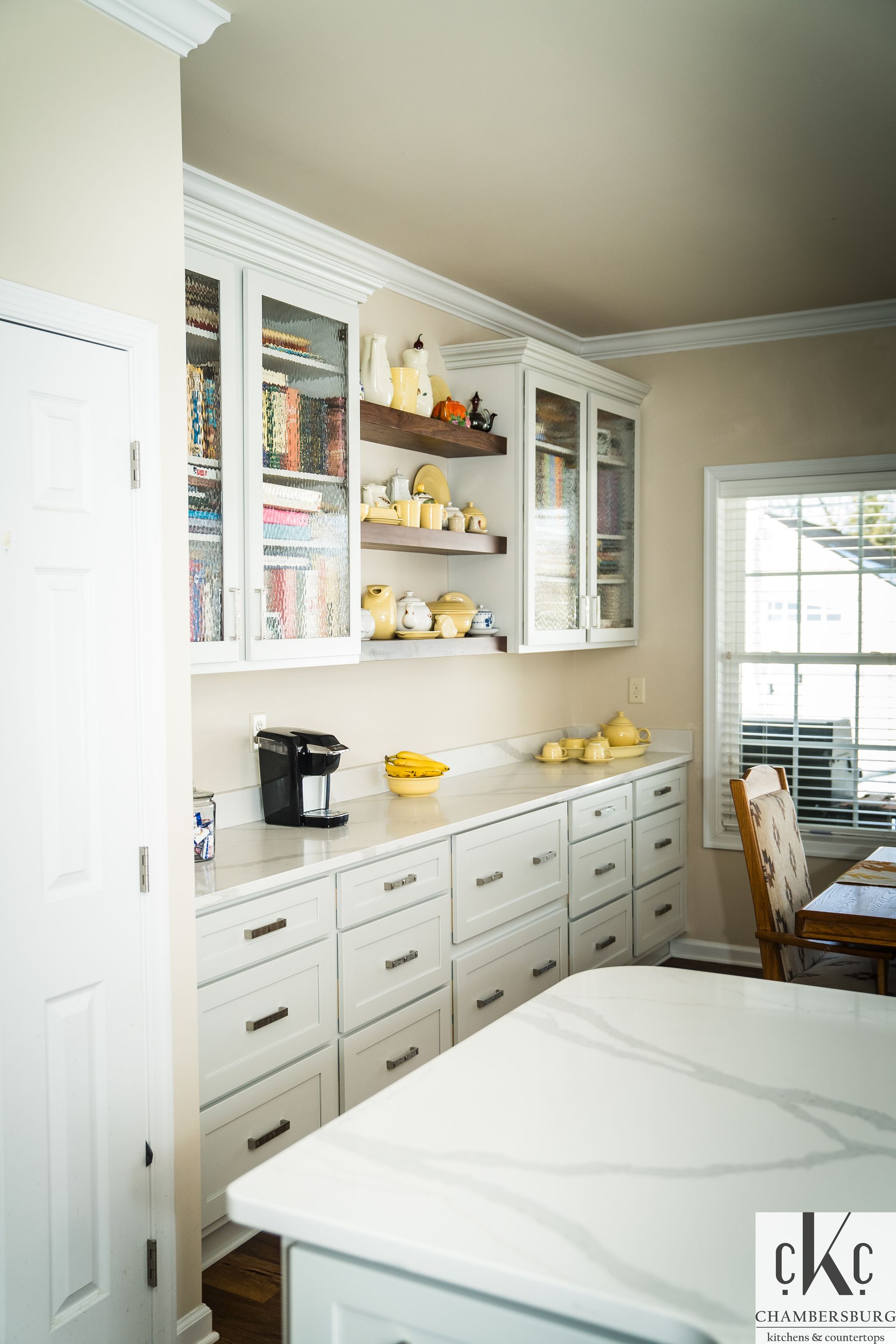 A kitchen with white cabinets and a white counter top.