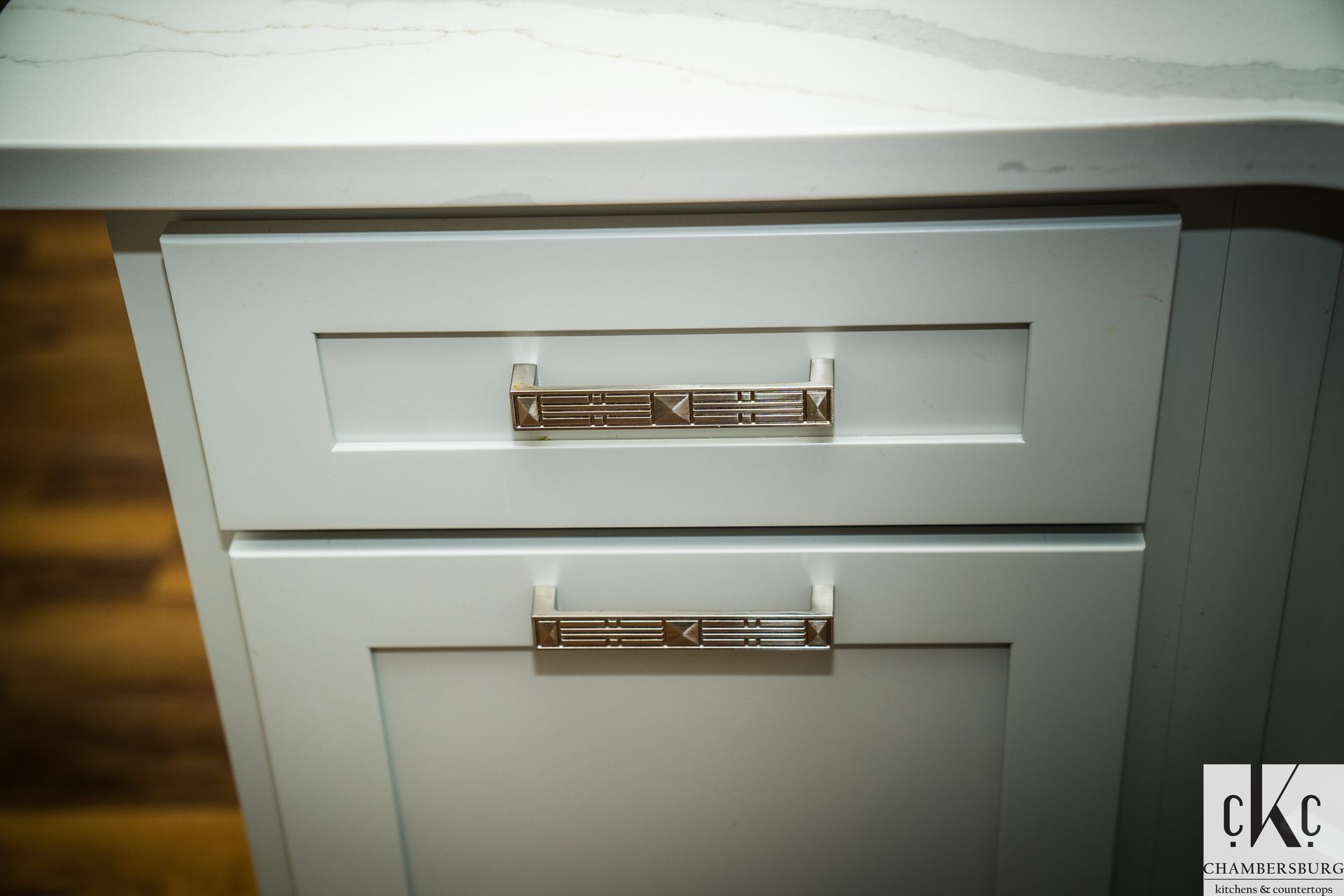 A close up of a white cabinet with silver handles