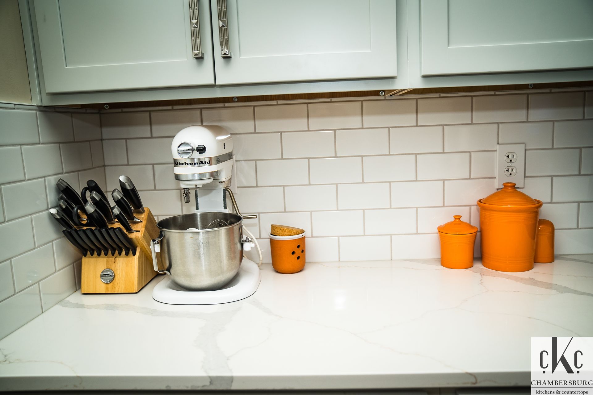A kitchen counter with a mixer and knives on it