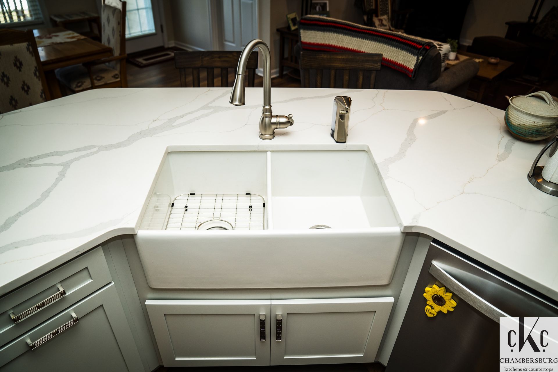 A kitchen sink with a faucet and a sunflower on the counter.