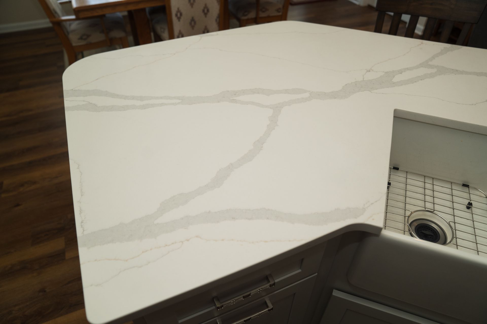 A kitchen counter with a marble counter top and a stainless steel sink.