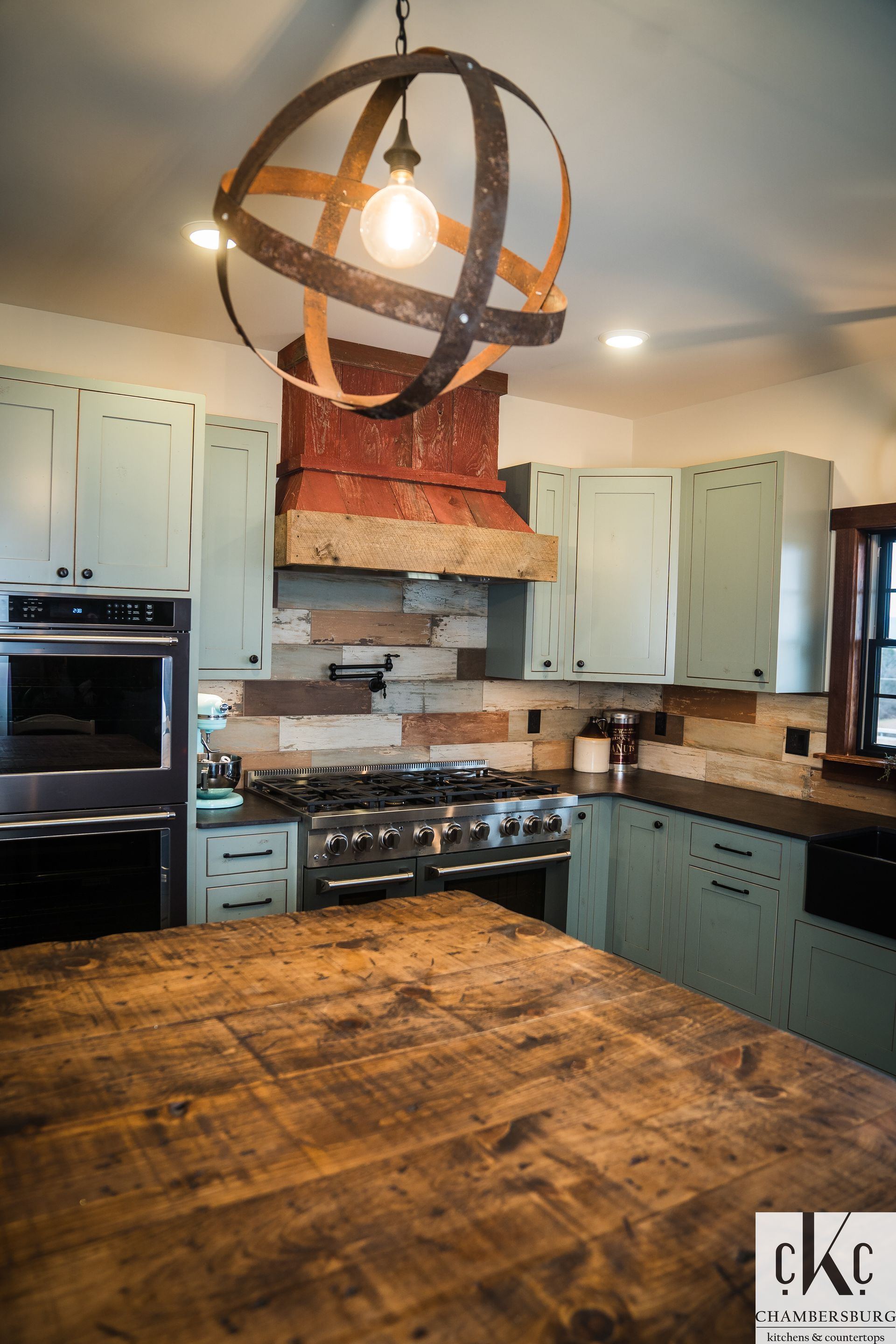 A kitchen with blue cabinets and a wooden counter top.