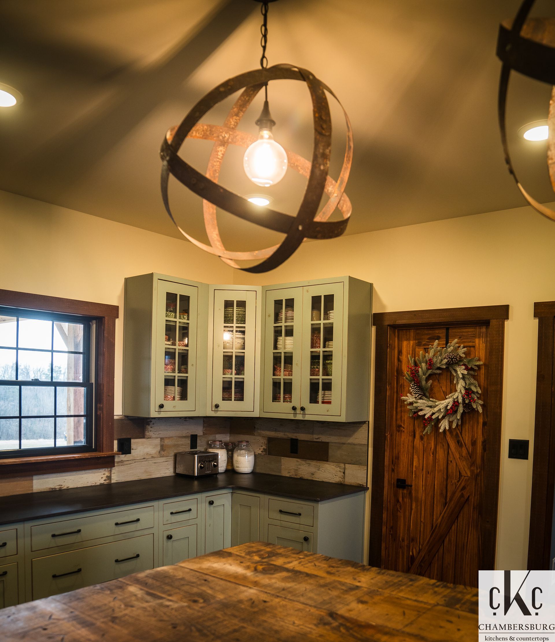 A kitchen with a light hanging from the ceiling and a sign that says ckc