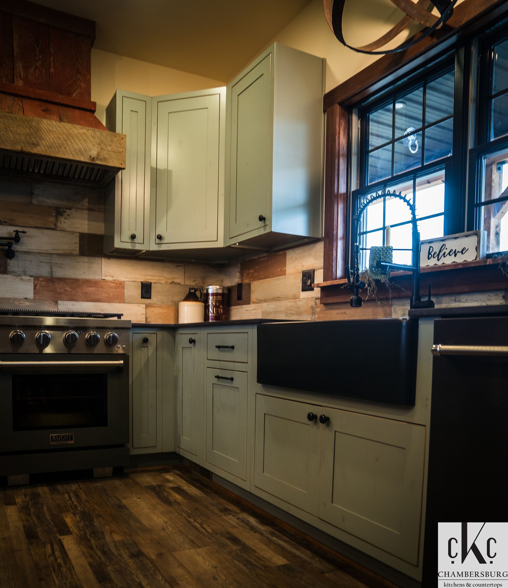 A kitchen with white cabinets and a black sink