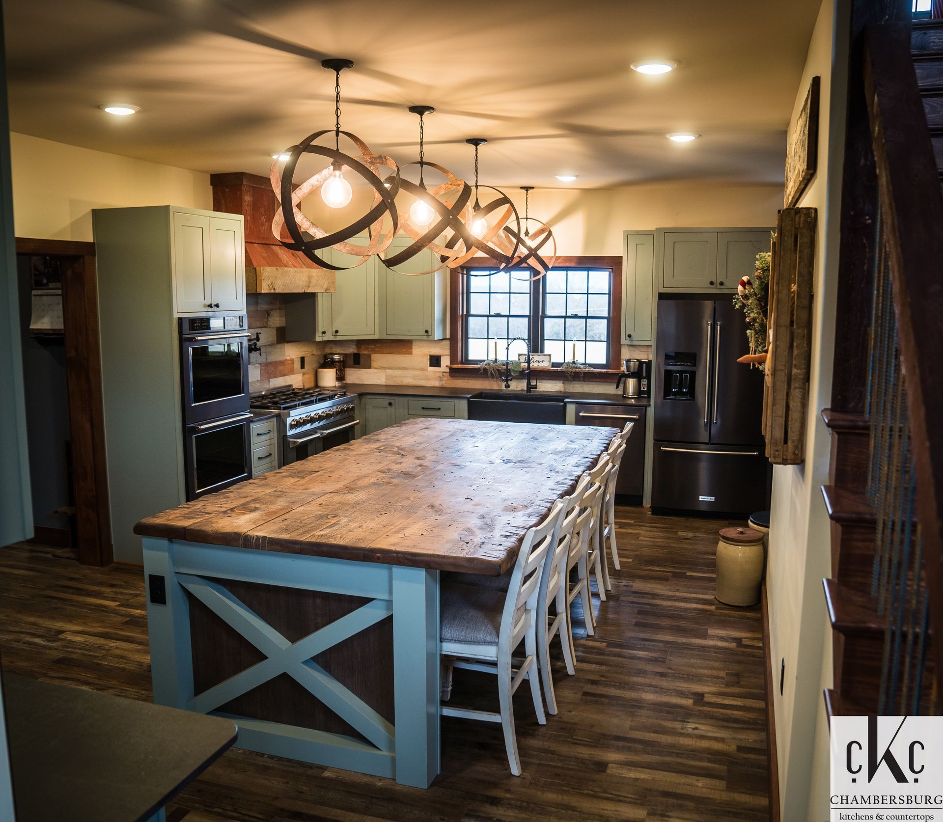 A kitchen with a large wooden table and chairs