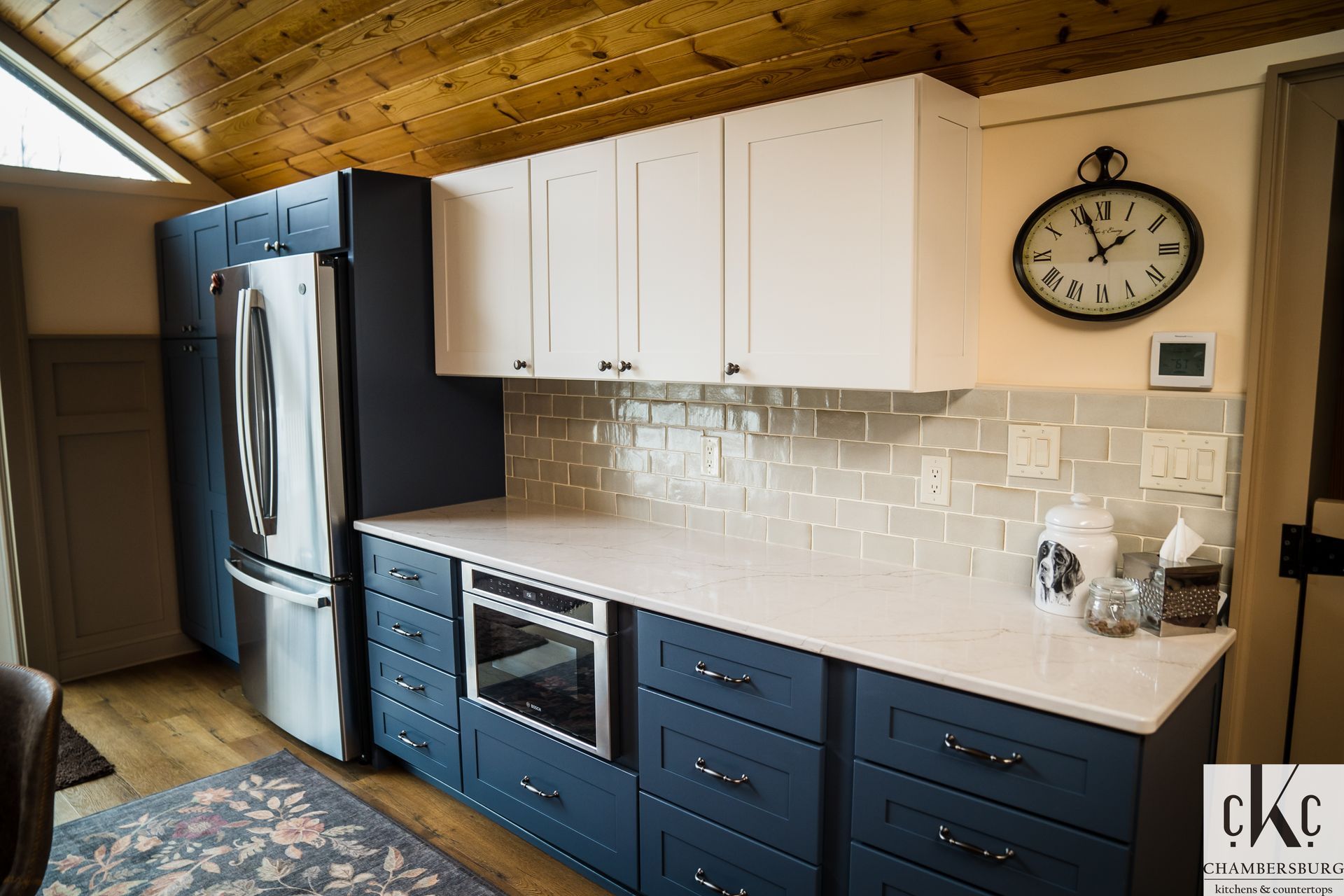 A kitchen with blue cabinets and a clock on the wall