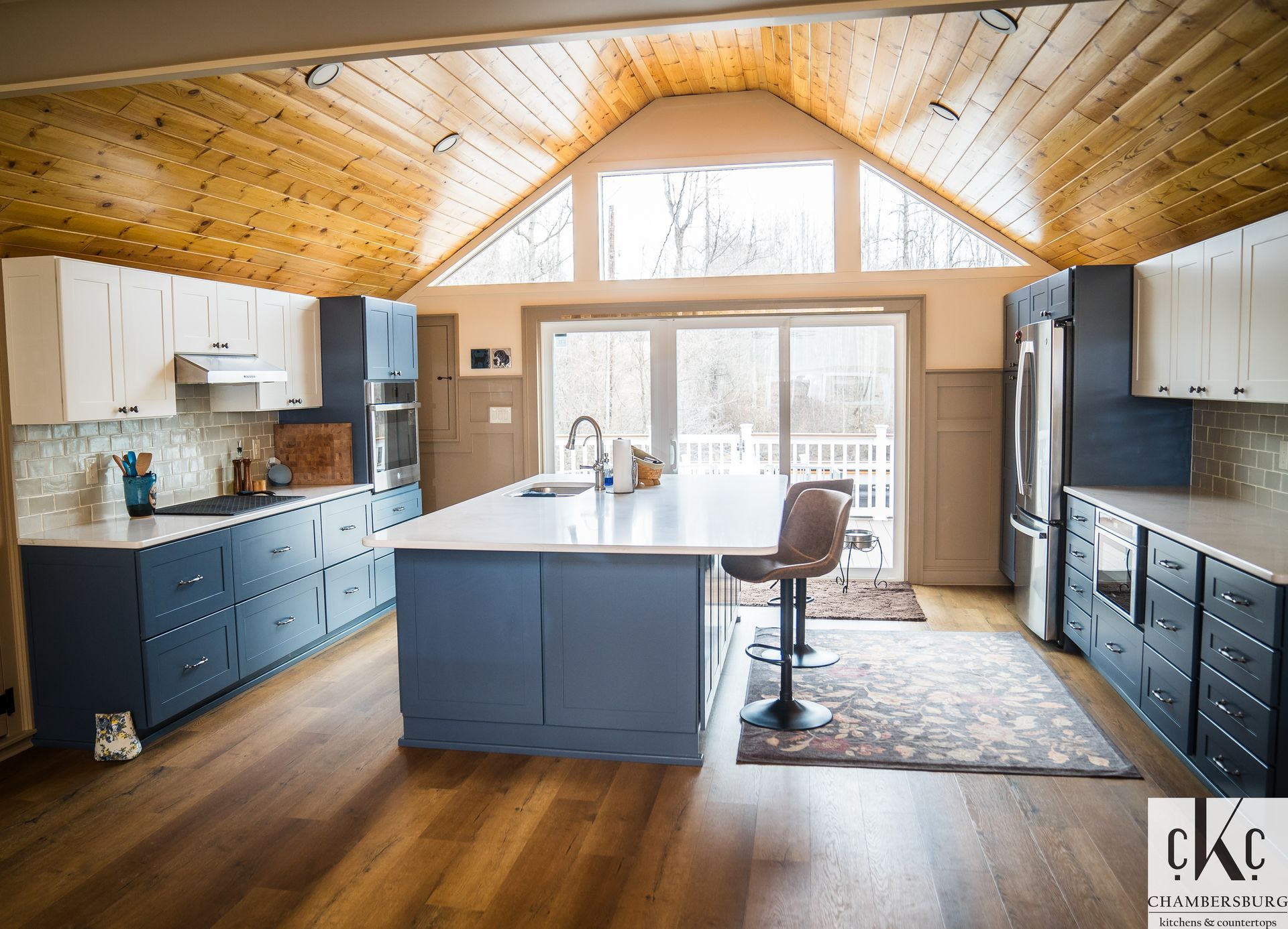 A large kitchen with blue cabinets and white counter tops