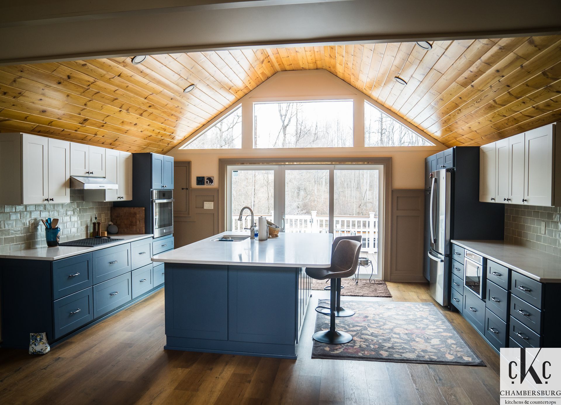 A large kitchen with blue cabinets and a large island