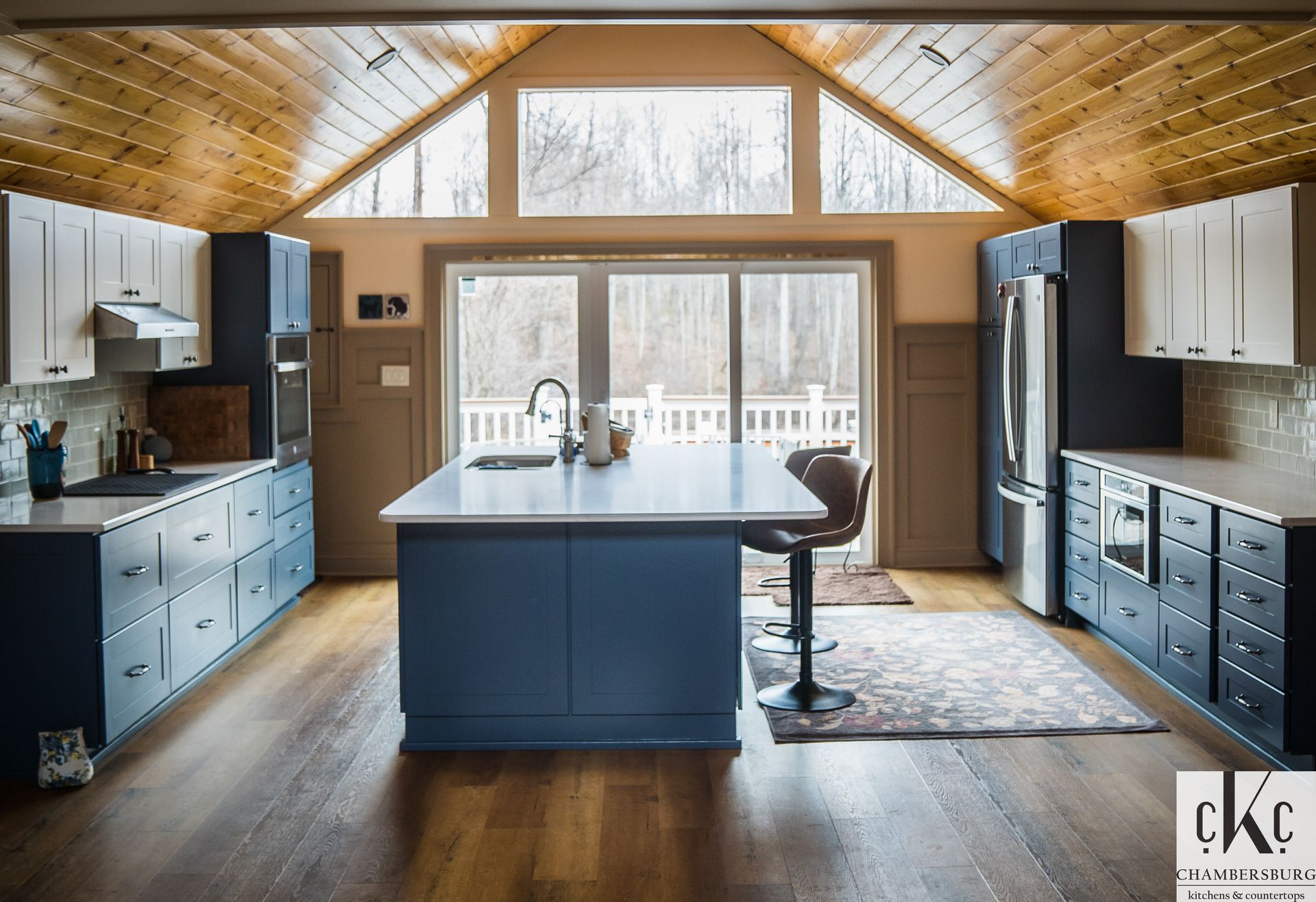 A kitchen with blue cabinets and a large island in the middle