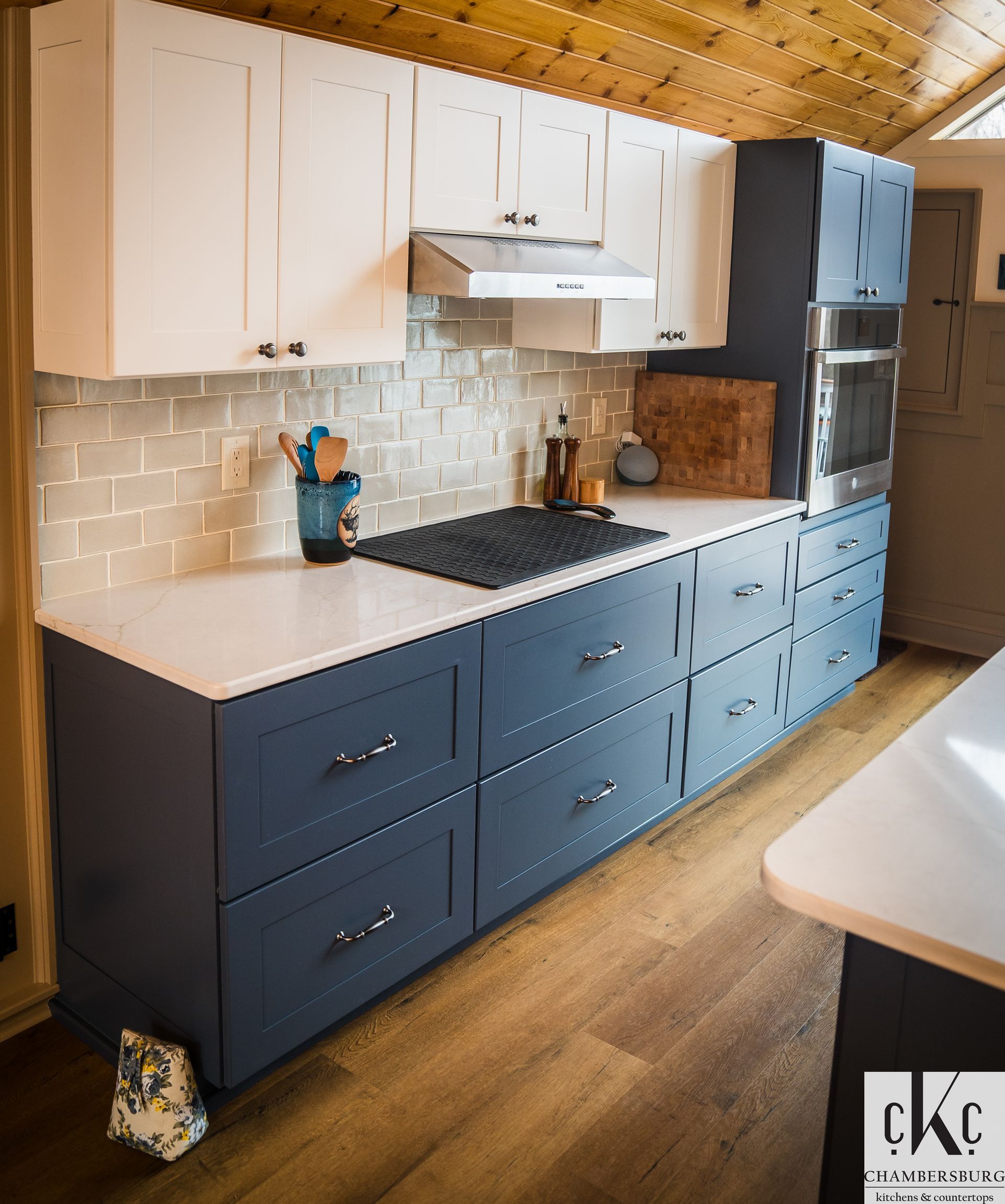 A kitchen with blue cabinets and white counter tops