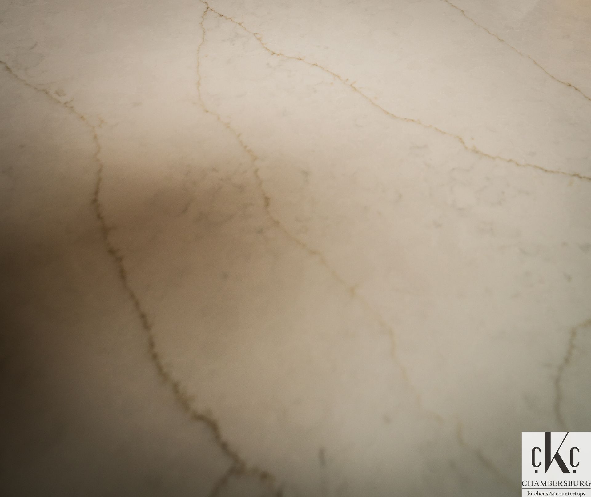 A close up of a white marble surface with a ckc logo in the corner