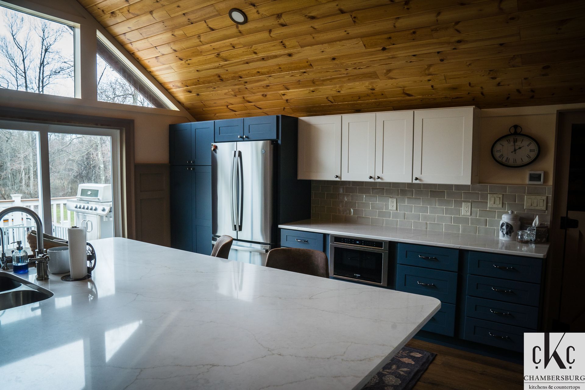 A kitchen with blue cabinets and white counter tops