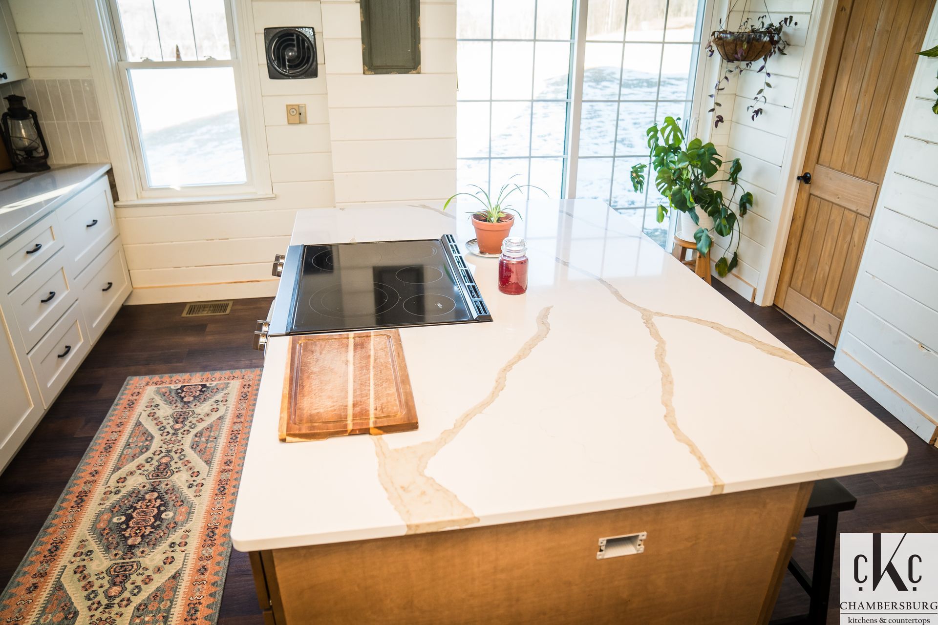 A kitchen with a large island and a stove top oven.