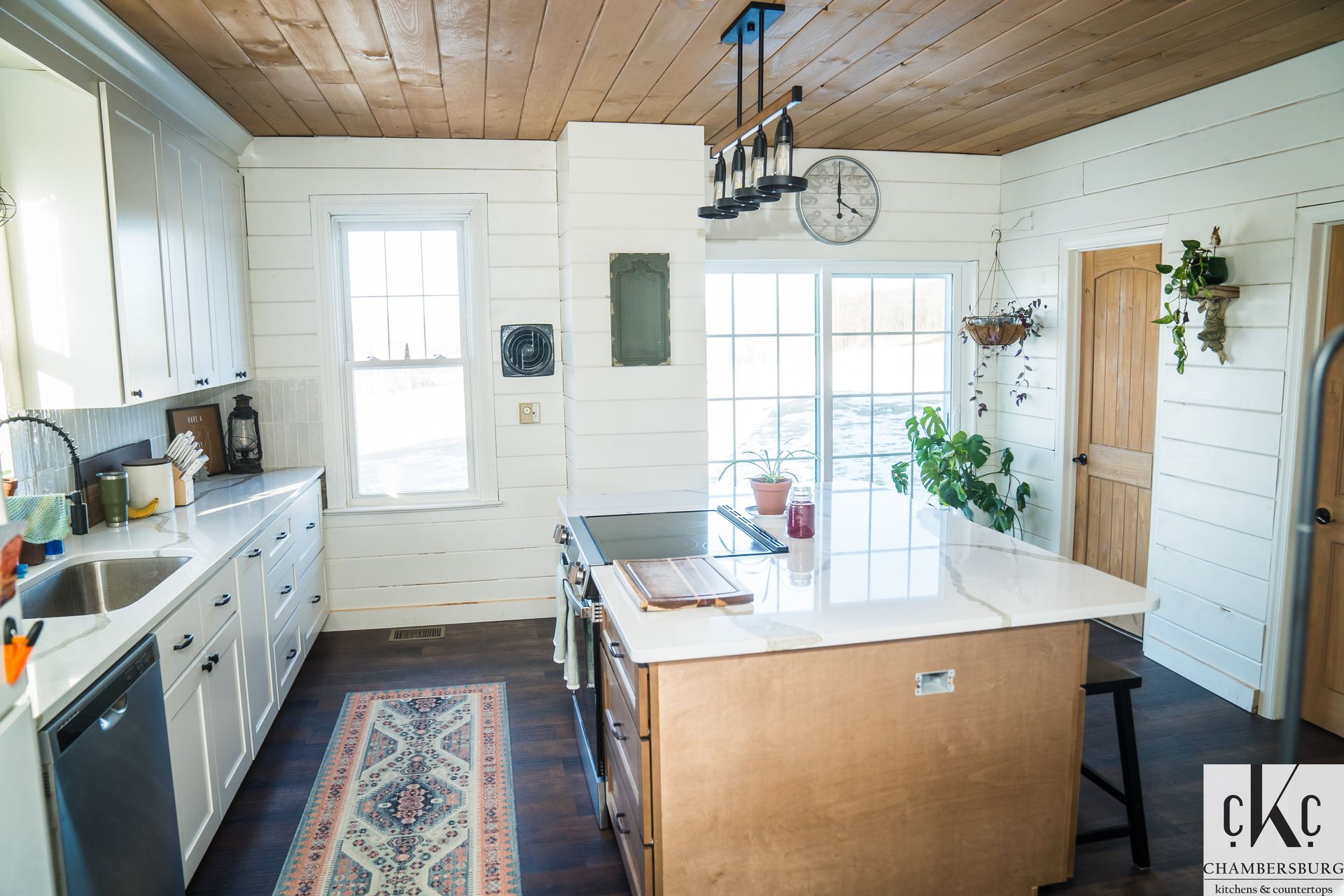 A kitchen with white cabinets and a large island in the middle