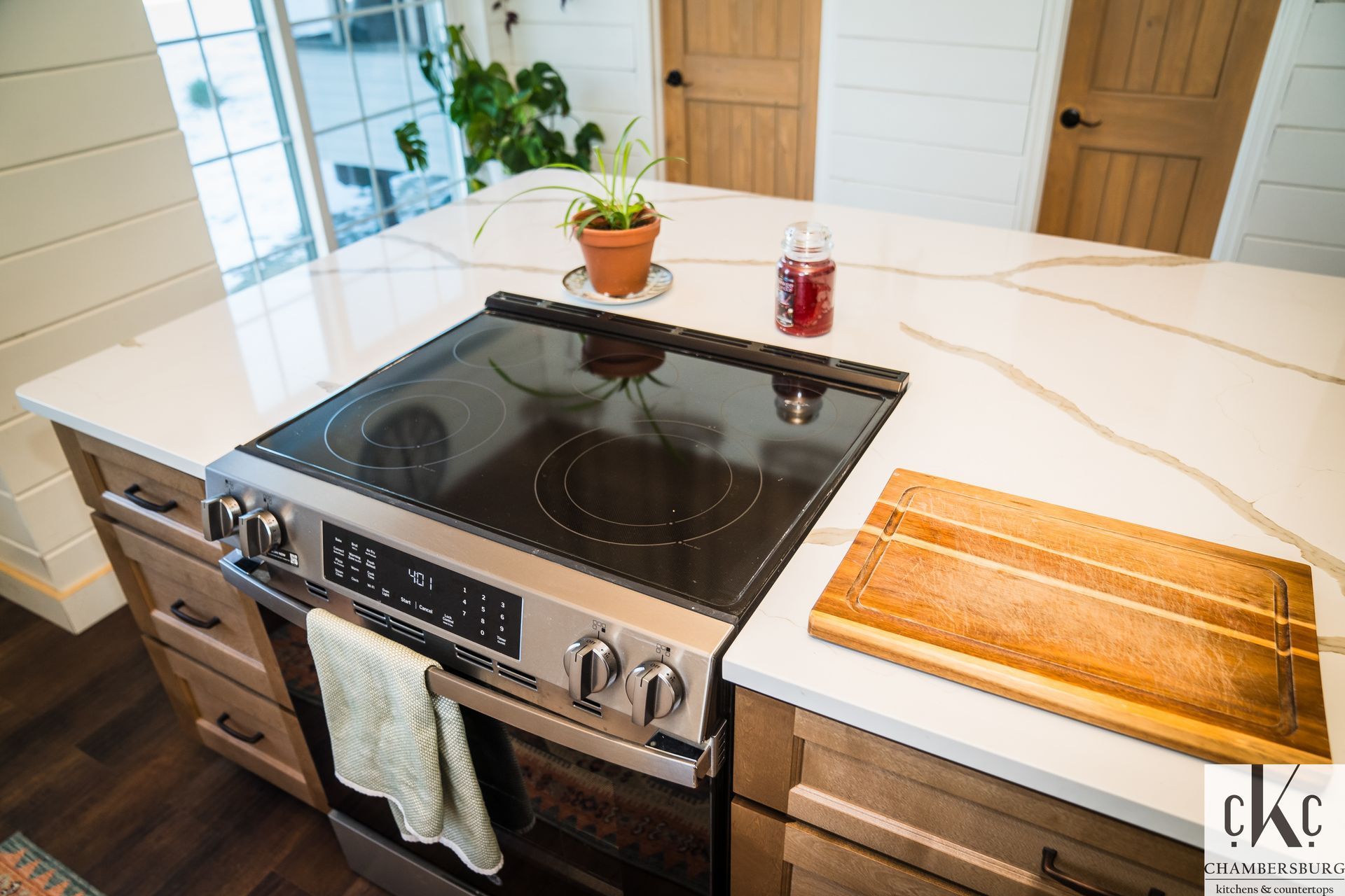 A kitchen with a stove and a cutting board on the counter.