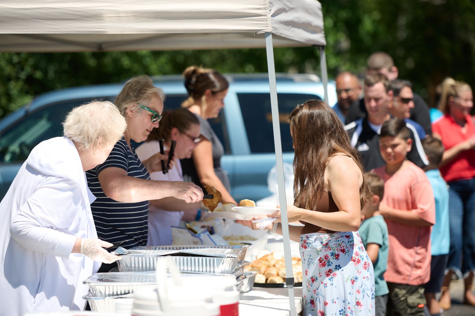 women serving food to parishioners, chicken after church event