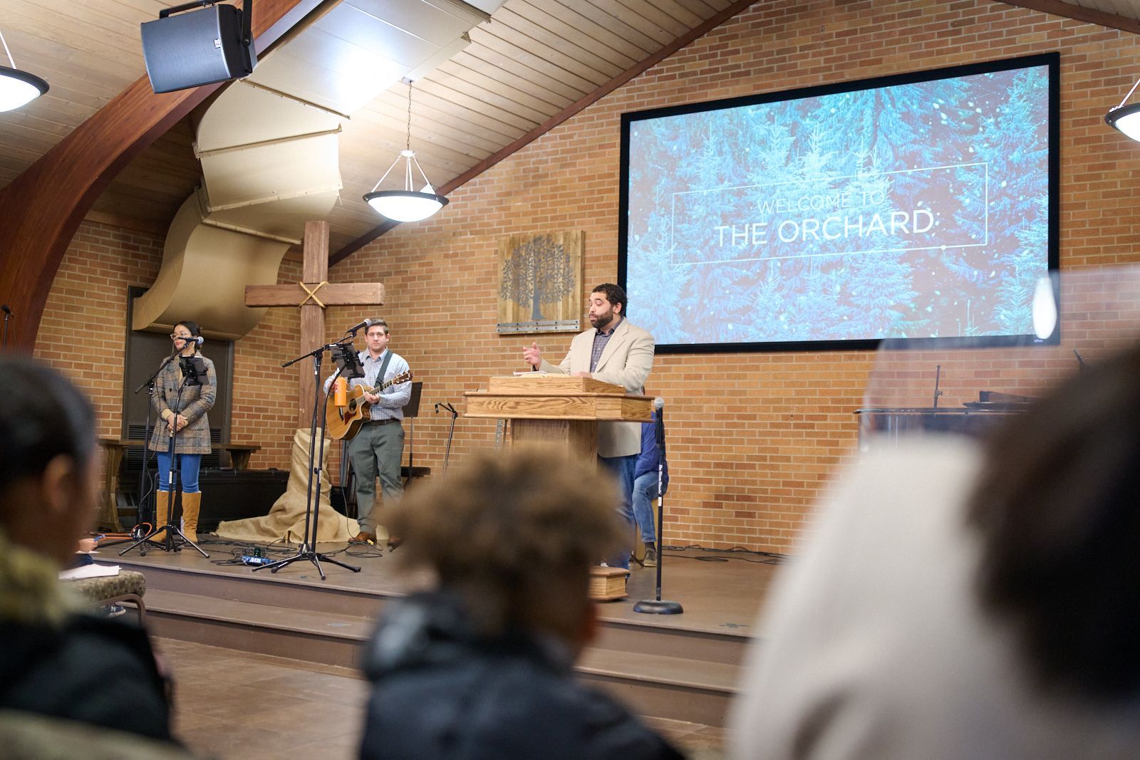 A pastor is standing at a podium in front of a crowd of people in a church, a sermon on how to get saved