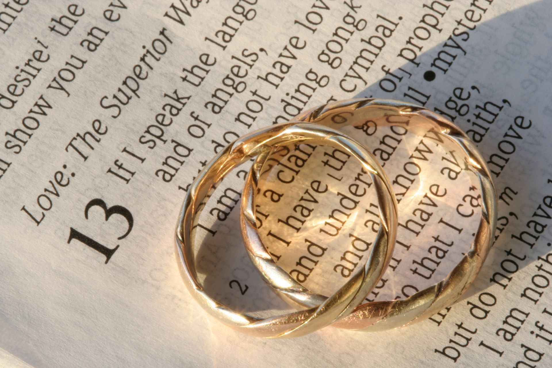 A couple of wedding rings laying on top of a bible highlighting the symbolism of god and marriage