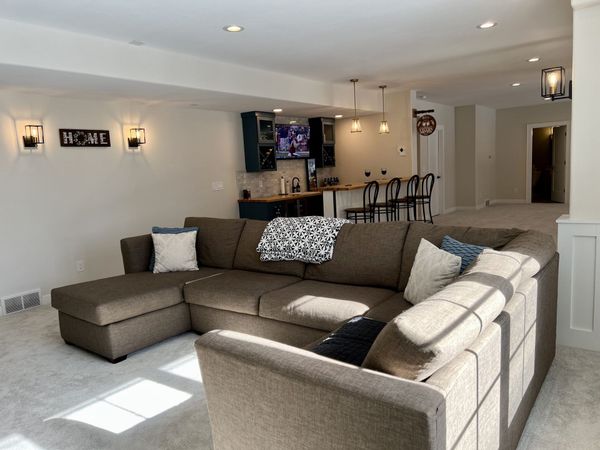 Remodeled basement space with a living room and wet bar addition