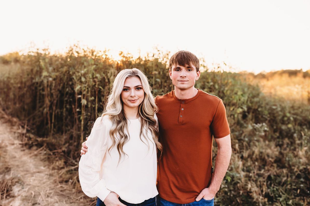A man and a woman are standing next to each other in a field.