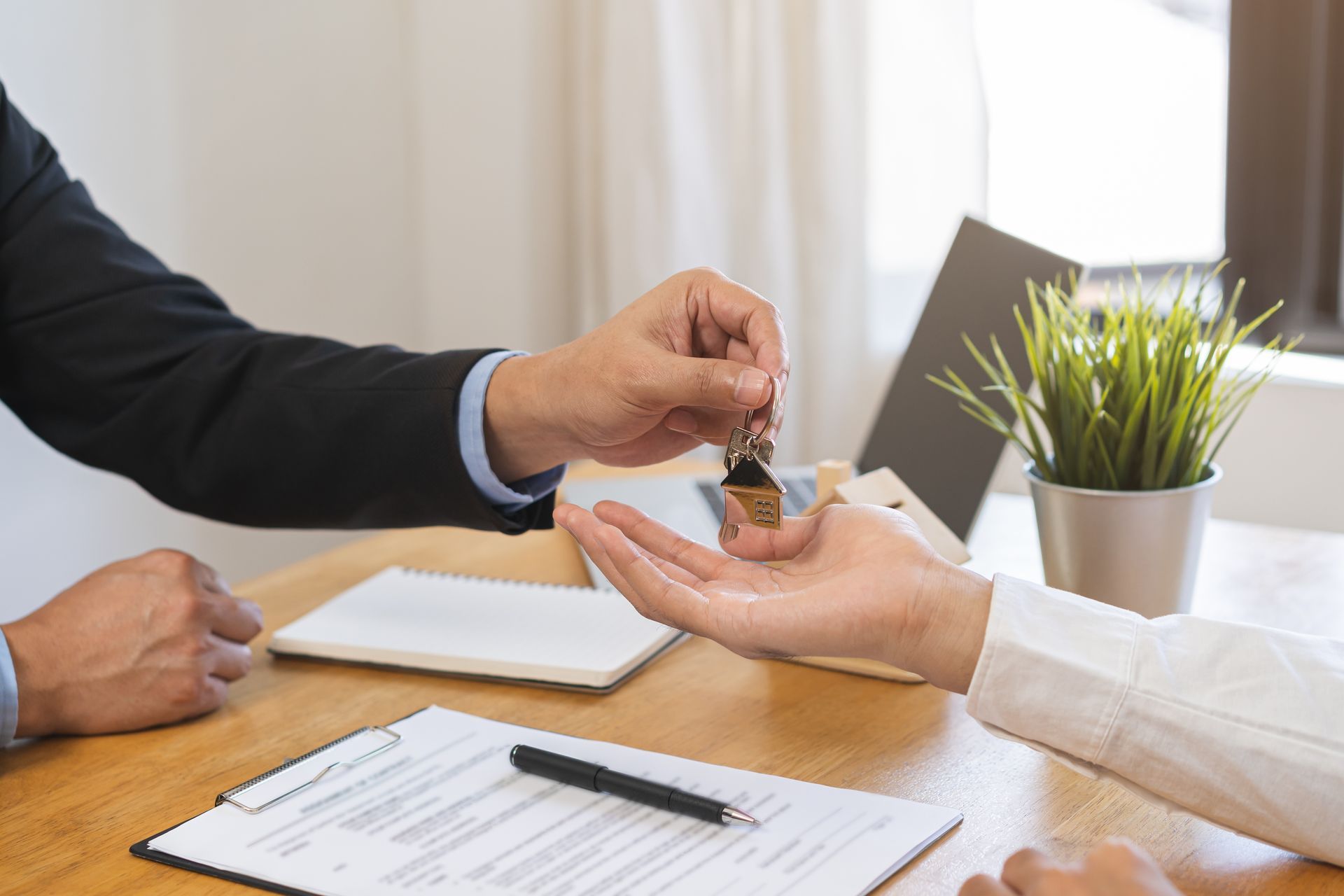 Person receiving a small bottle at a desk during a signing or handoff meeting.