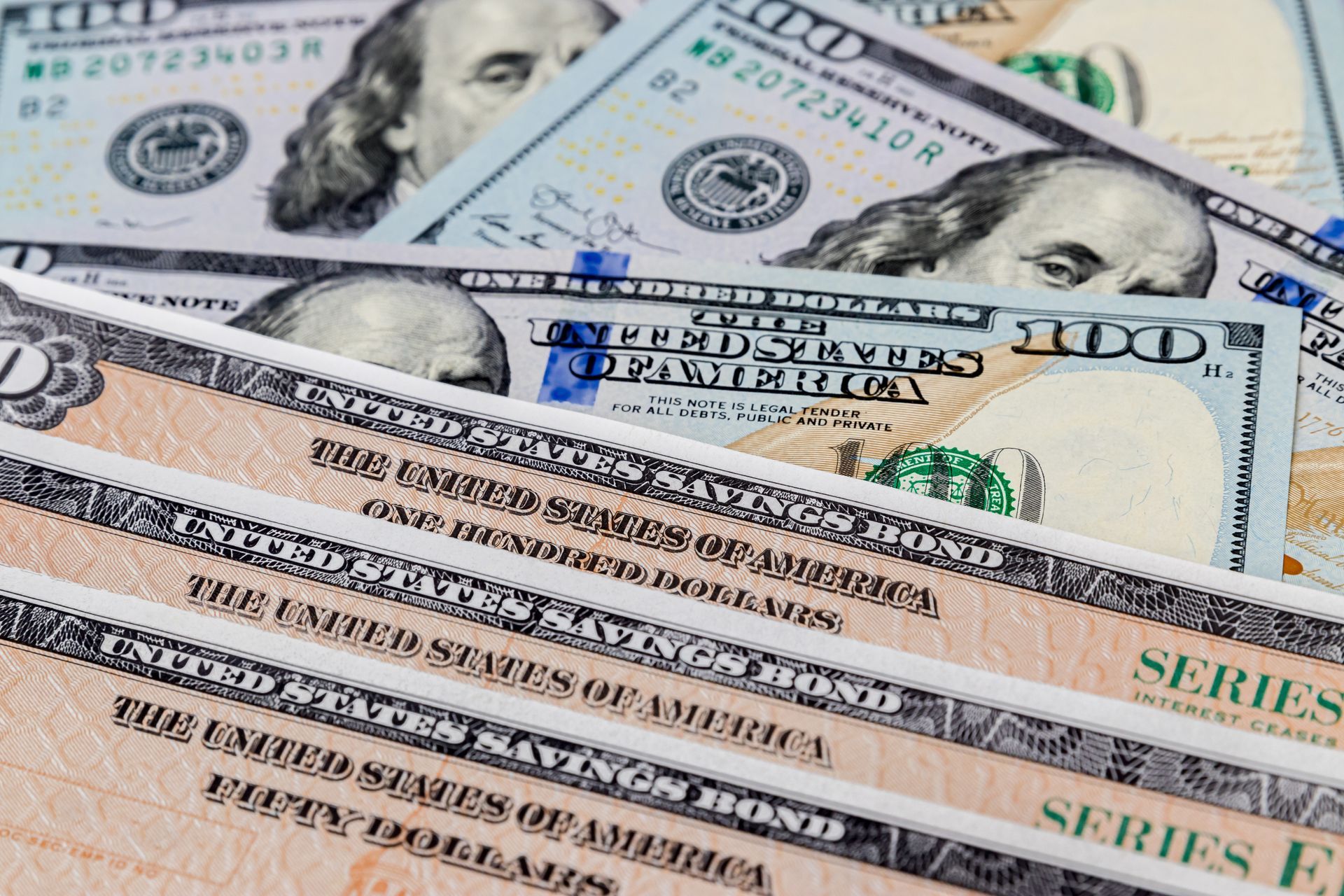 Stack of U.S. dollar bills fanned out, showing $100 and $20 notes.