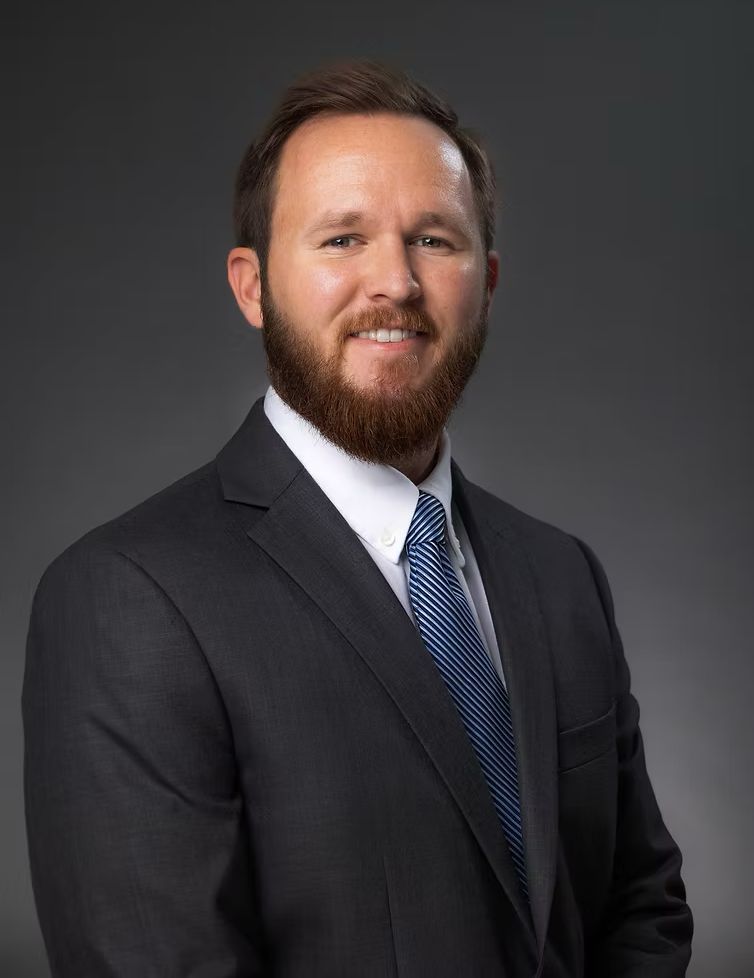 A man with a beard is wearing a suit and tie.