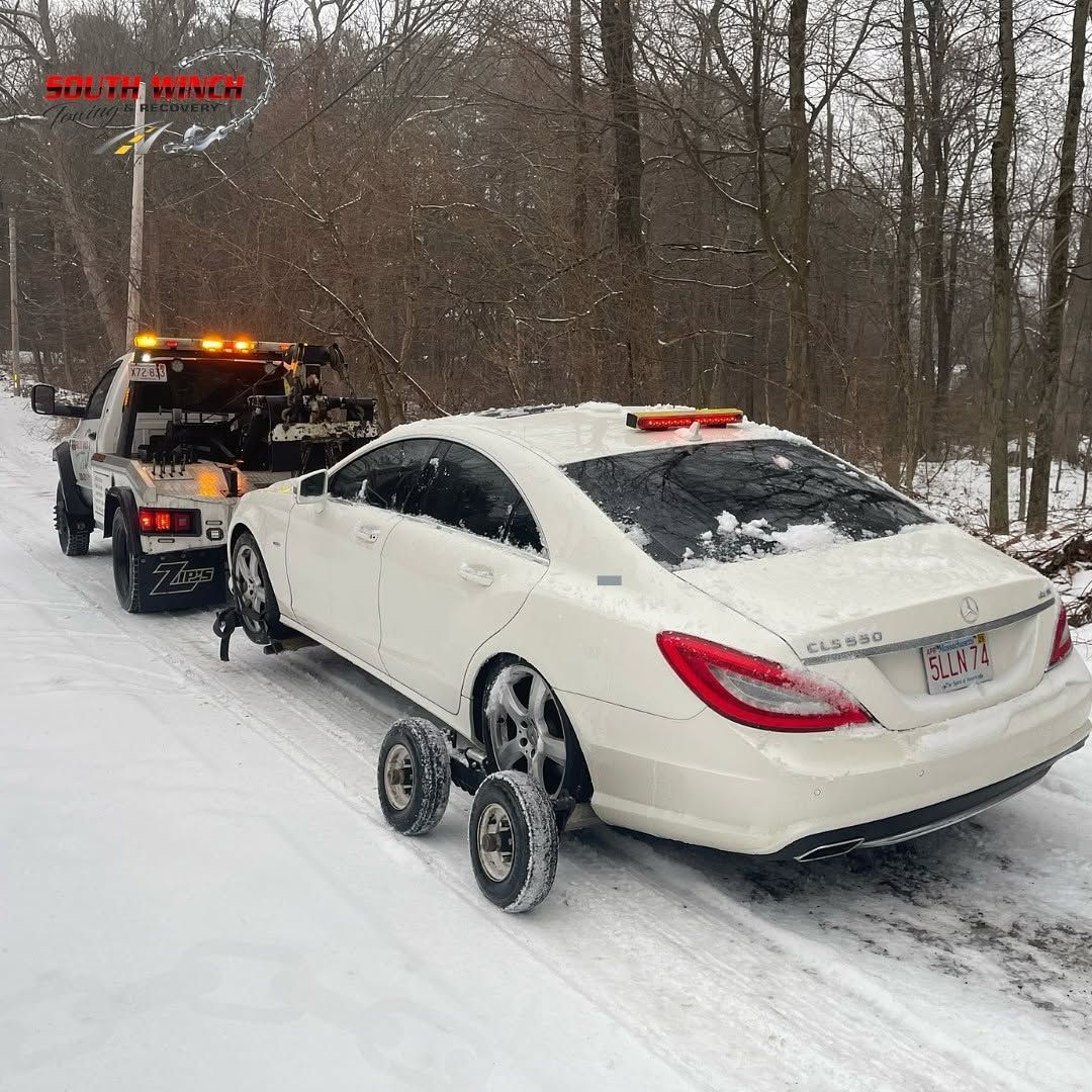 A tow truck is parked on the side of the road.