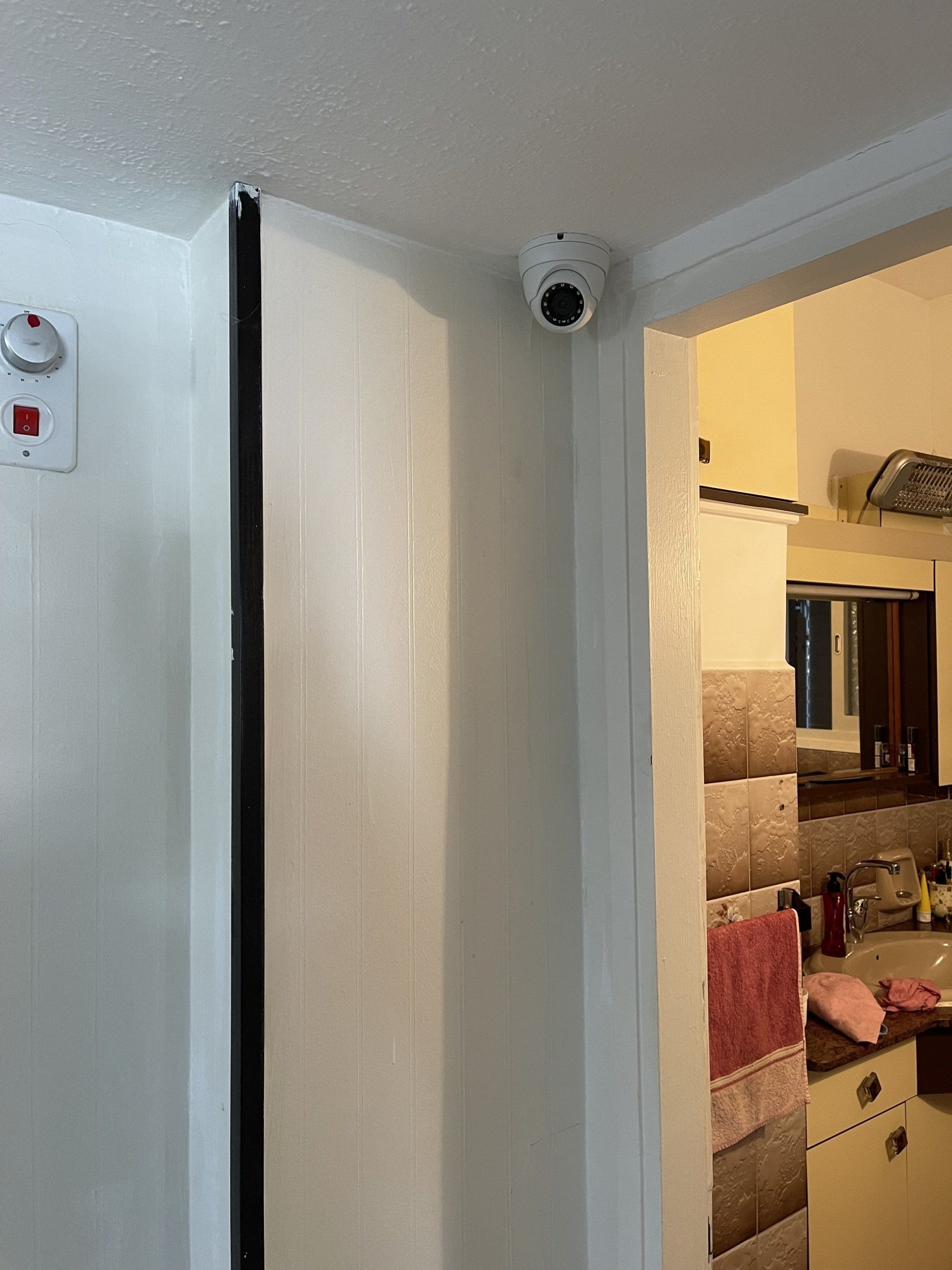 מצלמה מותקנת על קיר חדר ליד דלת.