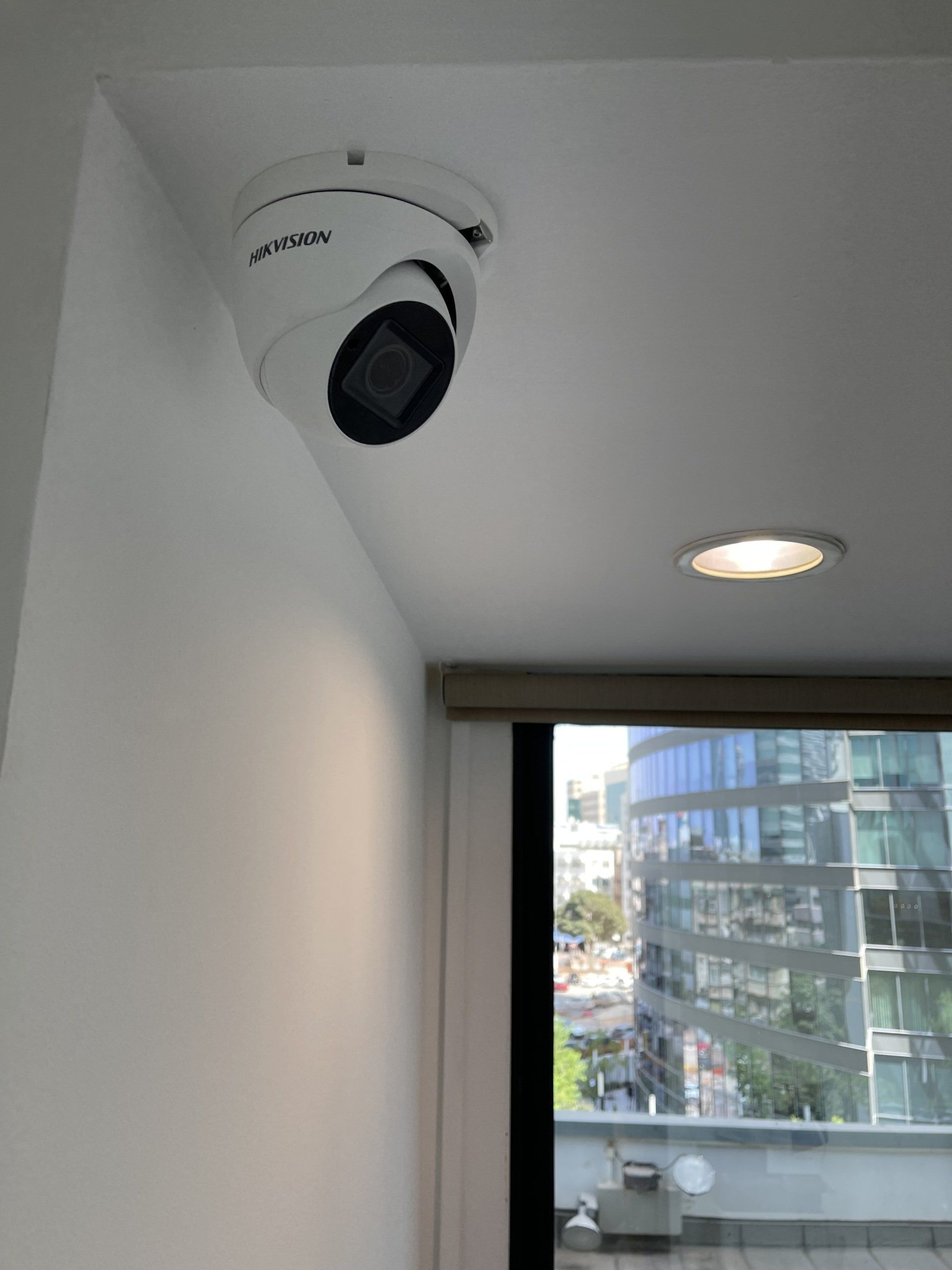 מצלמת אבטחה מותקנת לתקרה מעל חלון.